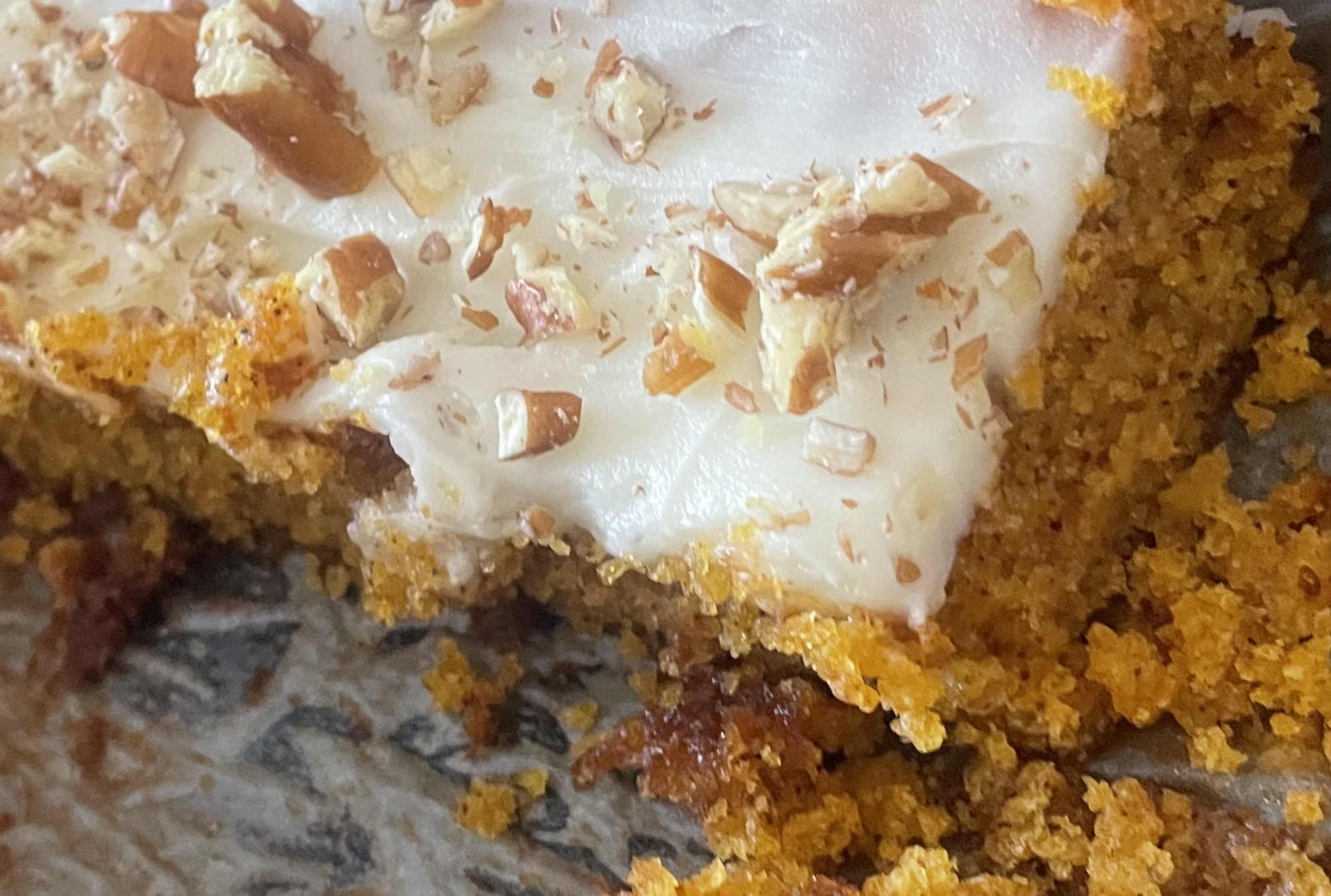 Cream Cheese frosting on a carrot cake bar. with Walnuts