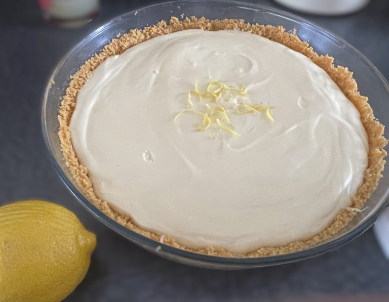 Gluten-free cheesecake topped with a lemon on the side